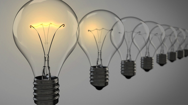 A row of clear light bulbs is lined up diagonally, with only the first bulb glowing while the others are off—a subtle reminder of how resources can spark inspiration and growth within a school community. The background is neutral and softly lit.