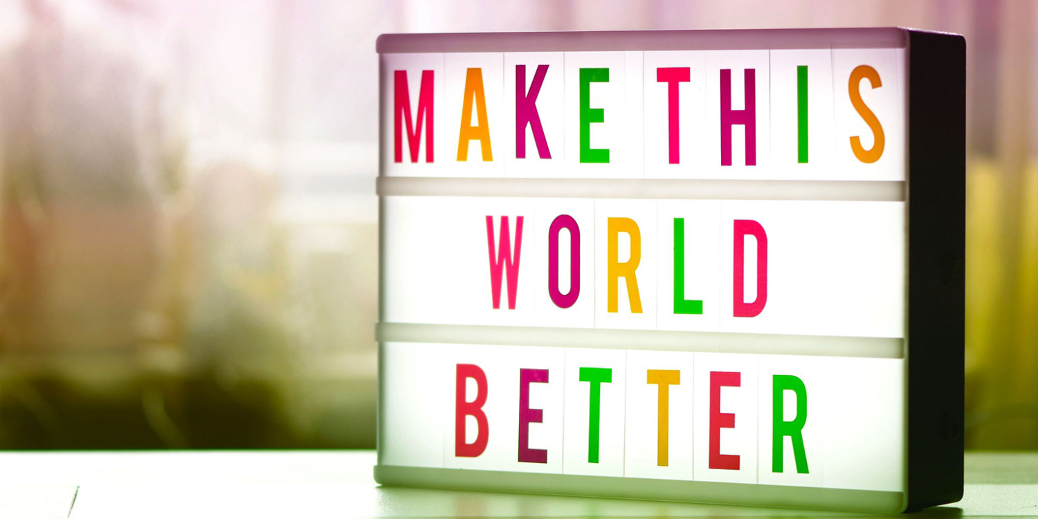 Header image for policy blog. Sign that says "Make This World Better"