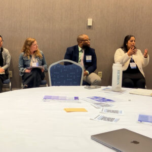 Jacqueline Monterroso, Director of Policy & Advocacy at Latinos for Education, speaks to the room as her fellow panelists to the right watch intently. 