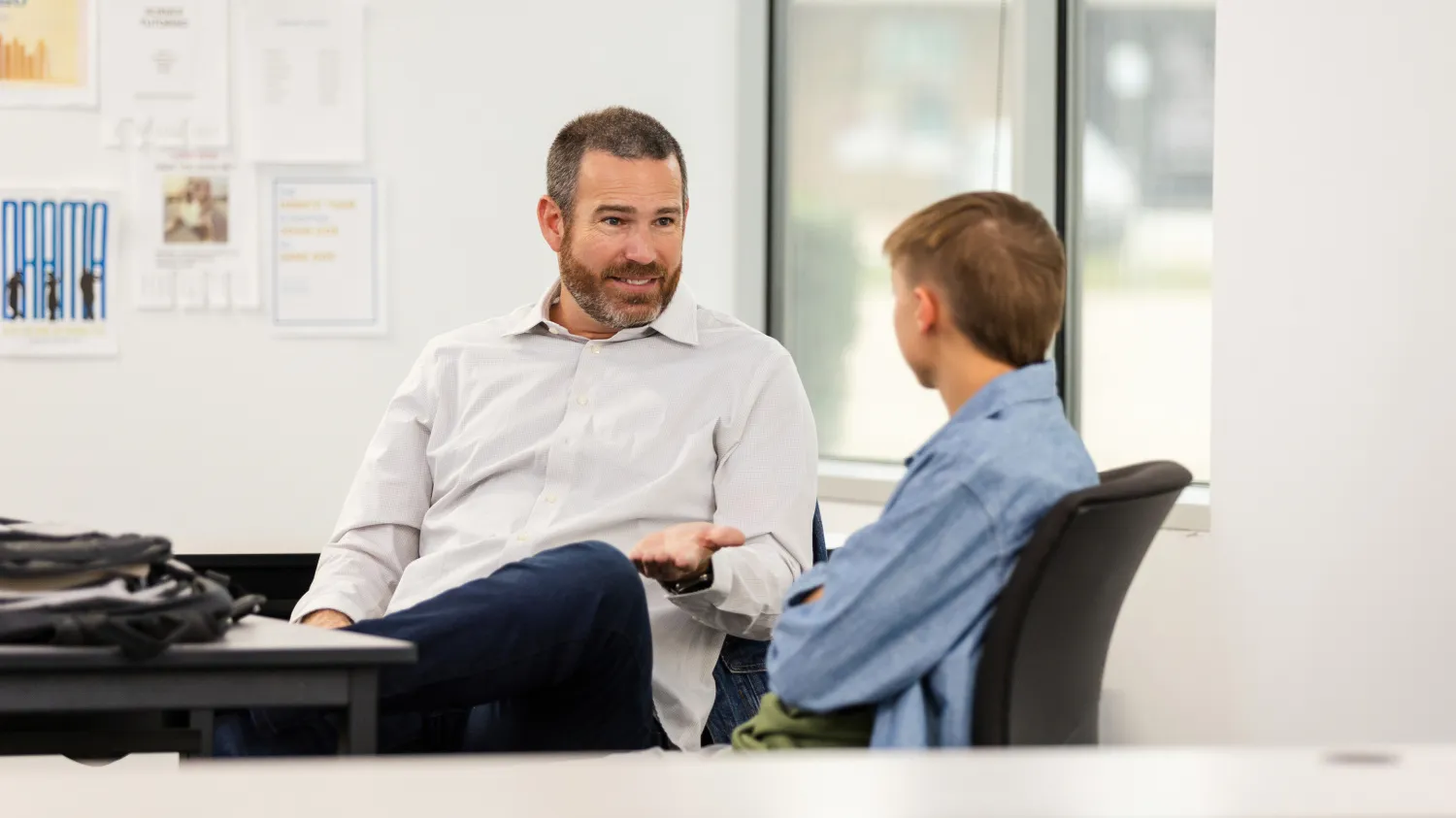 Click for Edutopia article. Picture of a principal speaking to a student.